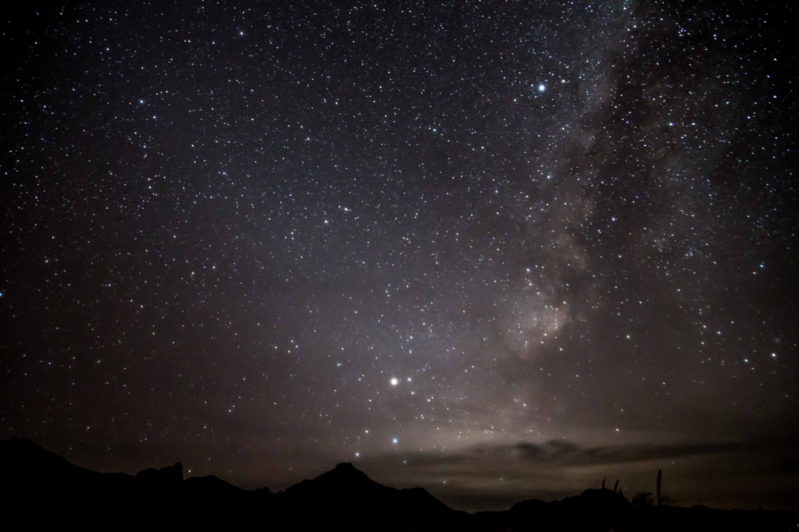The Milky Way rising over the silhouetted ridgeline of the Chisos Mountains in Big Bend National Park.