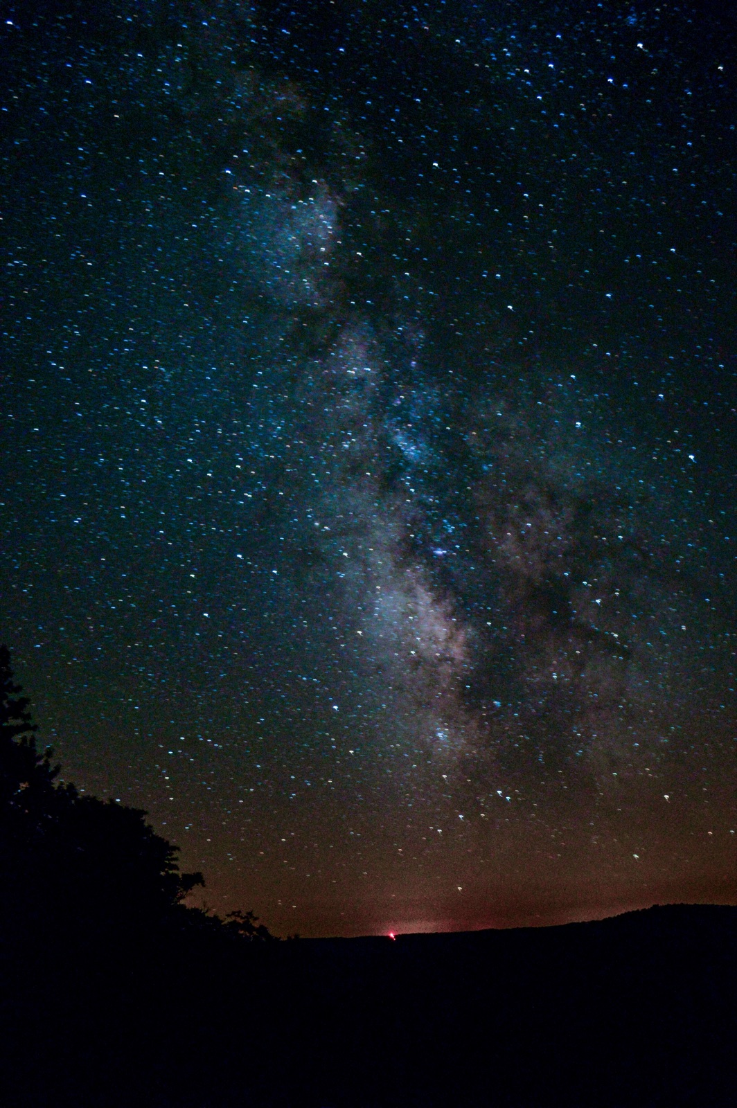 The Milky Way standing over a dark treeline at Cherry Springs State Park, Pennsylvania.